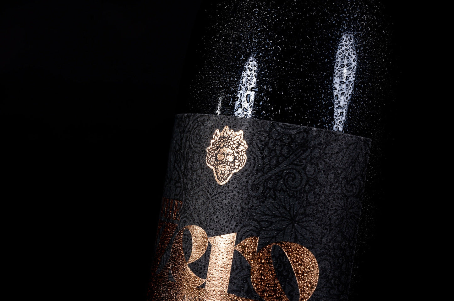 Detail van de zwarte fles van The Zero met gouden opdruk en het Bacchus-medaillon